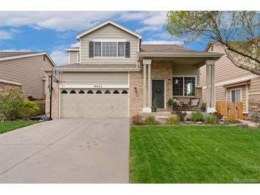 Charming two-story home with a well-manicured front yard and inviting porch at 10475 E Abilene St, Commerce City, CO 80022