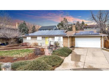 Charming ranch-style home with solar panels, a bright yellow door, and an attached garage at 7727 W 81St Pl, Arvada, CO 80005