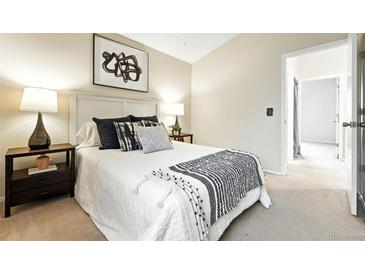 Cozy bedroom featuring a comfortable bed with stylish throw pillows and an ensuite bathroom at 1978 Newland Ct, Lakewood, CO 80214