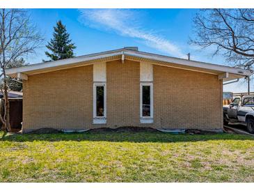 Tan brick house with a low-pitched roof and two tall, narrow windows at 1573 S Dexter Way, Denver, CO 80222
