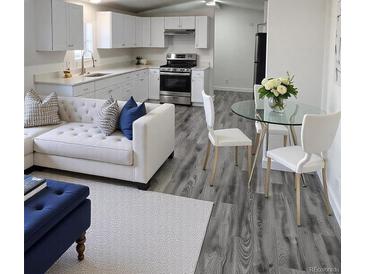 Cozy living room and kitchen with new appliances and modern finishes; ideal open-concept design at 3241 E 84Th Dr, Thornton, CO 80229