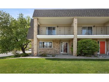 Inviting exterior view of townhome featuring a brick facade, balcony, and well-maintained lawn at 6711 S Race St, Centennial, CO 80122