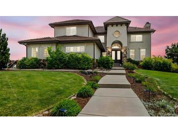 Elegant home featuring a meticulously landscaped yard, stone accents, and a charming walkway to the front entrance at 7724 Kryptonite Ln, Castle Rock, CO 80108