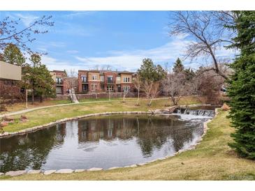 Exterior view of townhomes with water feature and a beautifully landscaped lawn at 9071 E Phillips Dr, Centennial, CO 80112