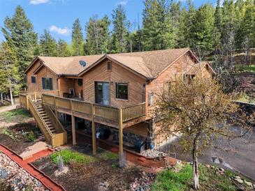 Charming two-story home with a lovely deck and meticulous landscaping in a gorgeous mountain setting at 29825 Kennedy Gulch Rd, Conifer, CO 80433