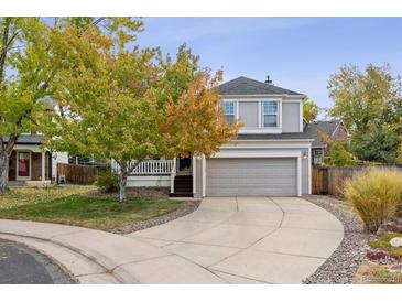 Charming two-story home with a two-car garage and inviting front porch, showcasing a well-manicured lawn at 8510 Union Cir, Arvada, CO 80005