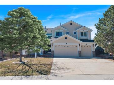 Inviting two-story home featuring a three-car garage and well-maintained landscaping at 7447 Soapstone Way, Castle Rock, CO 80108