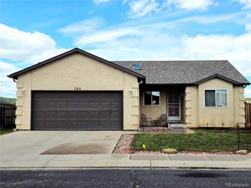 Charming ranch-style home featuring an attached garage, well-kept lawn, and front porch seating at 785 Century Ln, Monument, CO 80132