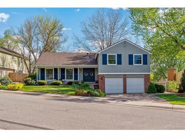 Charming two-story home with a well-manicured lawn, blue shutters, and an attached two-car garage at 6918 E Easter, Centennial, CO 80112