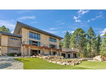Beautiful two-story home with a landscaped yard, a private putting green, a balcony, and an attached garage at 7793 Elk Path Way, Morrison, CO 80465