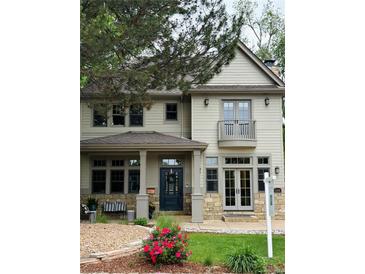 Charming two-story home featuring a welcoming front porch and a Juliet balcony at 2486 S Monroe St. St, Denver, CO 80210