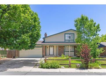 Charming two-story home featuring a well-manicured lawn, brick accents and attached two car garage at 1584 S Fraser Way, Aurora, CO 80012