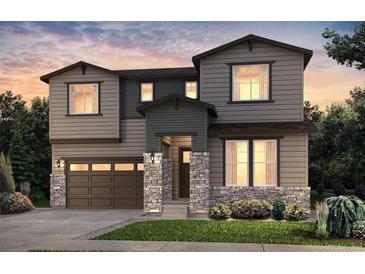Charming two-story home featuring a stone pillar front porch, complemented by lush landscaping and an attached two car garage at 3818 N Duquesne St, Aurora, CO 80019