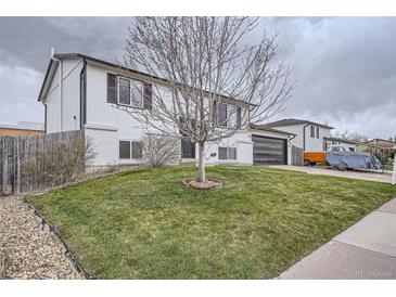 Charming two-story home with a well-manicured lawn and attached garage under a cloudy sky at 6592 S Cody Way, Littleton, CO 80123