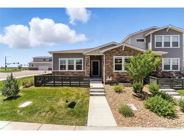Charming home featuring a stone facade, well-maintained lawn, and inviting entrance in a vibrant community at 15501 E 112Th Ave # 6F, Commerce City, CO 80022