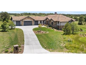 Stunning home boasts a long driveway, three-car garage, and lush landscaping at 8625 Eagle Moon Way, Parker, CO 80134