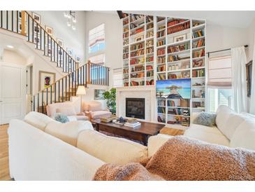 Bright living room with a floor-to-ceiling custom bookcase and fireplace at 1455 Flowers Ct, Erie, CO 80516