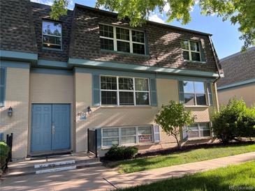 Two story condominium building with a tan brick facade, blue trim, and well-manicured lawn at 9440 E Girard Ave # 1, Denver, CO 80231