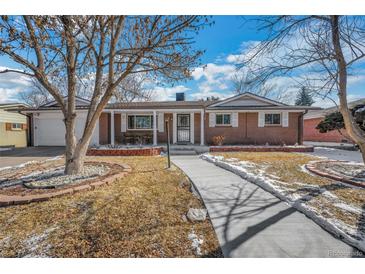 Charming brick home with a covered porch, manicured lawn, and inviting walkway at 2694 S Krameria St, Denver, CO 80222