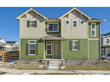 Charming two-story home with a green and beige exterior and well-maintained landscaping at 10196 Worchester St, Commerce City, CO 80022