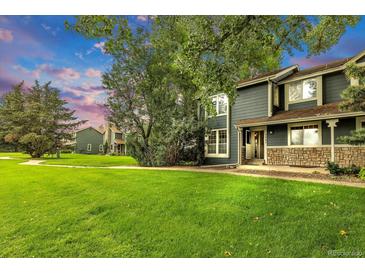 Inviting home with well-manicured lawn, stone accents, and lush trees creates a welcoming curb appeal at 3807 Paseo Del Prado, Boulder, CO 80301