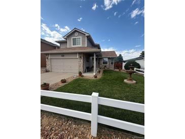 Charming home with manicured lawn, white picket fence, and stone accents on the facade at 2551 W 58Th W Ave, Denver, CO 80221
