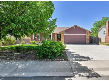 Charming single-story home with a well-maintained lawn and a spacious driveway under a clear, blue sky at 18874 E Colorado Dr, Aurora, CO 80017