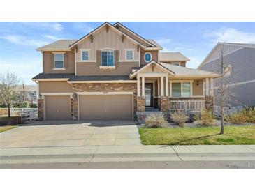 Charming two-story home with a well-manicured lawn, stone accents, and a welcoming front porch at 20145 E Fair Ln, Centennial, CO 80016