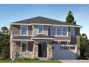 Charming two-story home featuring a stone-accented porch and attached garage at 767 Raindance St, Erie, CO 80516