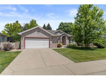 Charming brick home with a well-manicured lawn and an attached two-car garage at 329 Bobcat Pt, Lafayette, CO 80026