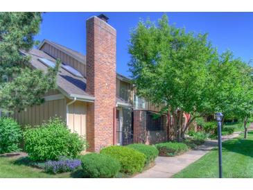Inviting home exterior featuring a brick chimney, mature trees, and well-maintained landscaping for a warm and welcoming curb appeal at 11884 Elk Head Range Rd, Littleton, CO 80127