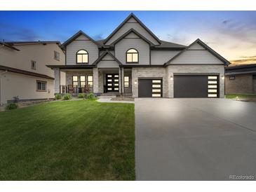Beautiful two-story home with a well-manicured lawn, stone accents, and a modern garage door design at 27250 E Nova Cir, Aurora, CO 80016