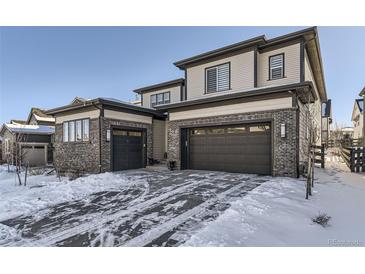 Two-story home with attached two-car garage and snow-covered driveway at 6506 Barnstead Dr, Castle Pines, CO 80108