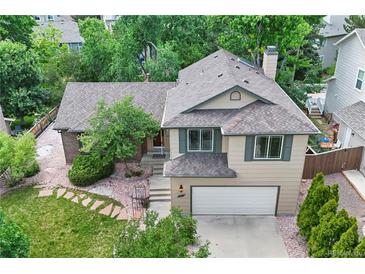 Charming two-story home with neutral siding, a two-car garage, and mature landscaping at 8725 Meadowlark Cir, Highlands Ranch, CO 80126