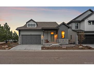 Charming single Gathering home with gray exterior, stone accents, and a two-car garage at 7010 Homeplace Pt, Castle Rock, CO 80108