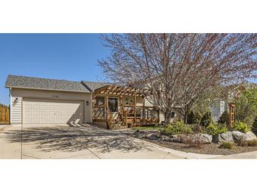 Charming home featuring a garage, covered porch, and well-maintained landscaping with a beautiful mature tree at 1141 Beech St, Fort Lupton, CO 80621