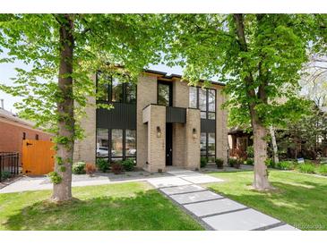 Striking modern home featuring a tan brick facade, expansive windows, and a welcoming walkway at 1241 S Garfield St, Denver, CO 80210