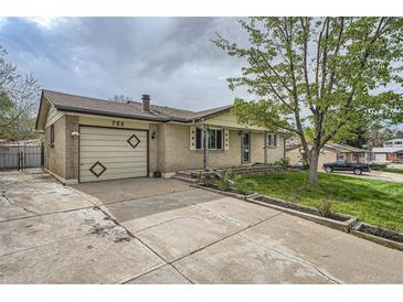 Charming single-story home with a brick facade, well-manicured lawn, and an attached garage at 755 Braun St, Lakewood, CO 80401