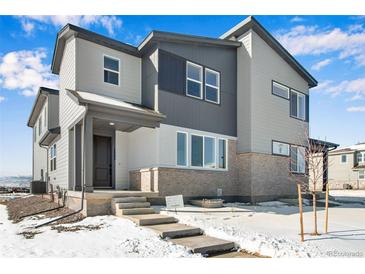 Charming two-story home featuring modern gray siding, brick accents, and a welcoming front porch at 1525 E 3Rd Ave, Longmont, CO 80501