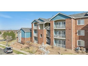 Charming condo building featuring brick facade, balconies, and well-maintained landscaping at 2705 S Danube Way # 101, Aurora, CO 80013