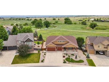Expansive aerial view of a well-maintained home with a three-car garage, landscaped yard, and open green space behind the home at 1100 Columbine Way, Erie, CO 80516