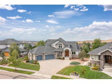 Beautiful two-story home with stone accents, a three-car garage, and a well-manicured lawn at 1199 Links Ct, Erie, CO 80516