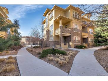 Beautiful townhouse with stone accents, balconies, manicured landscaping, and winding walkways at 7887 Vallagio Ln, Englewood, CO 80112