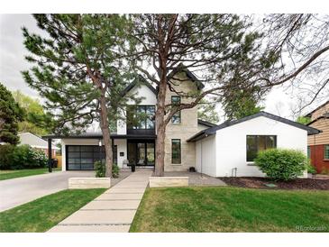 Modern home featuring a stone facade, black trim, and a well-manicured front lawn at 62 Jasmine St, Denver, CO 80220