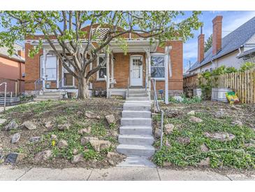 Charming brick home with a large tree in the front yard and inviting front porch at 4910 W 34Th Ave, Denver, CO 80212