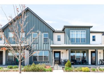 Stylish home featuring a modern design with vertical siding, large windows and a welcoming front porch at 5025 Central Park Blvd, Denver, CO 80238