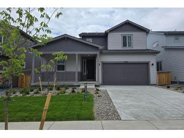 Charming two-story home with a covered porch, gray exterior, and well-manicured front yard at 1300 Loraine N Cir, Lafayette, CO 80026