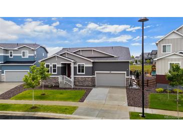 Charming home featuring stone accents, a two-car garage, and a well-maintained front yard at 1677 Meagan Way, Erie, CO 80516