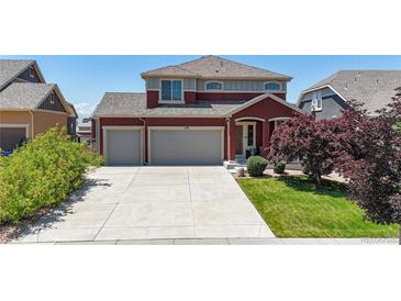 Two-story home featuring a two-car garage, concrete driveway and well maintained lawn at 172 Painted Horse Way, Erie, CO 80516