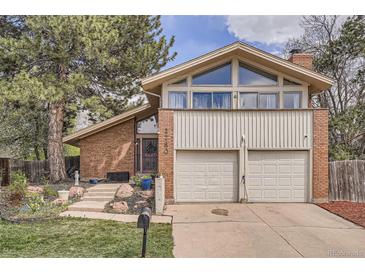 Inviting two-story home features a brick facade, two-car garage, and well-manicured front yard at 2780 S Oakland W Cir, Aurora, CO 80014